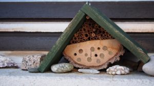 Ein kleines Insektenhotel mit grünem Dach.