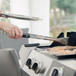Eine Frau grillt an einem Gasgrill