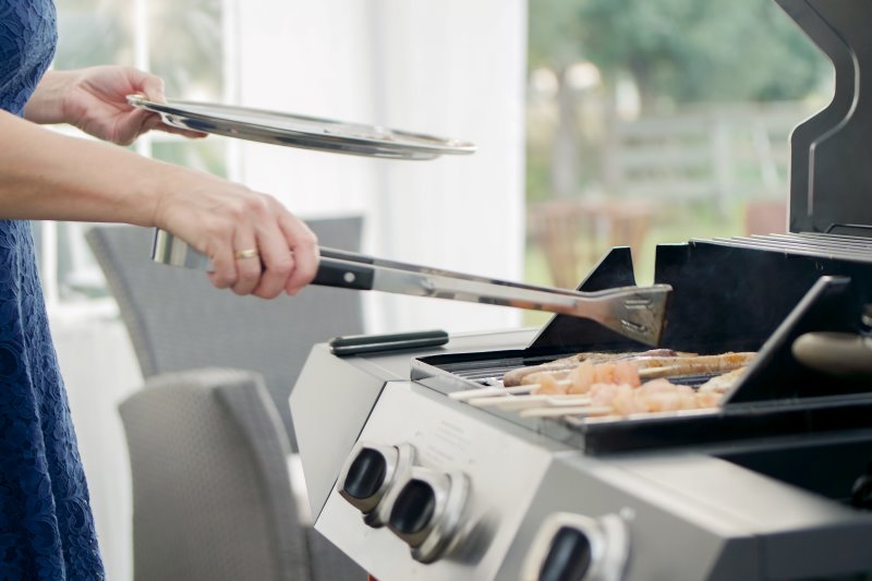 Eine Frau grillt an einem Gasgrill