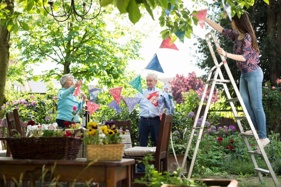 grandparents-and-granddaughter-hanging-up-bunting-2025-04-04-21-11-59-utc